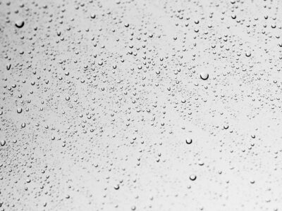 The image shows a close-up view of a surface covered with numerous small water droplets, likely condensation on glass or a glazed ceramic surface. The varying sizes and distribution of the droplets suggest testing or observation of surface wettability, hydrophobicity, or coating performance. This type of visual is commonly used in surface energy analysis or anti-fog/anti-wetting studies for glass and ceramic materials.