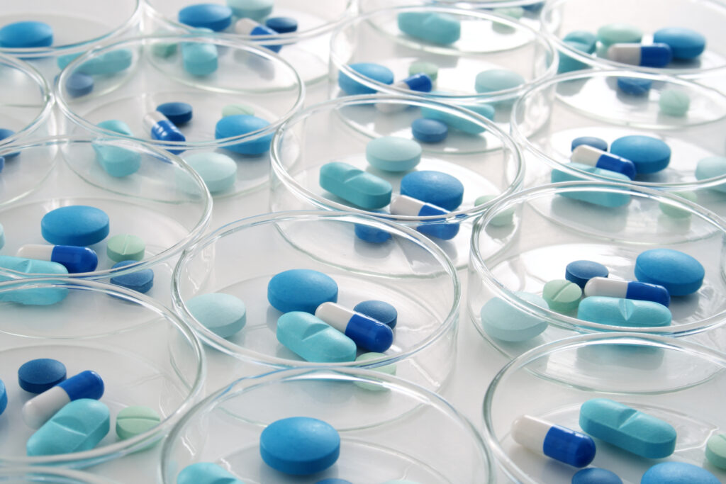 Clusters of blue pills arranged in a series of petridishes.