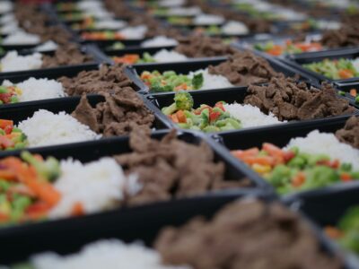 Boxed lunches with rice, vegetables, and meat ready to be packed.